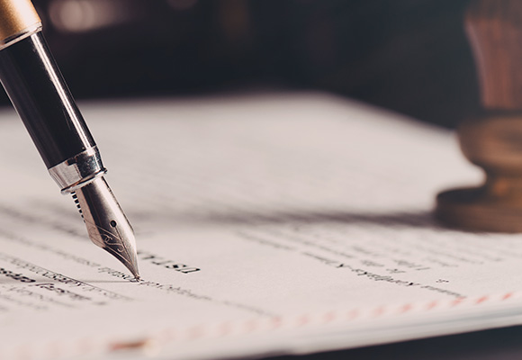 fountain pen writing on paper with visible text and a wooden stamp in the background three key points for clarity